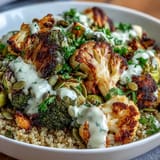 This healthy Roasted Brassica Bowl features a colorful mix of tender roasted vegetables and hearty grains, topped with toasted pumpkin seeds and fresh parsley.  