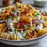 Creamy avocado ranch pasta salad with taco flavors, Doritos crunch, and fresh vegetables in a vibrant Tex-Mex dish.