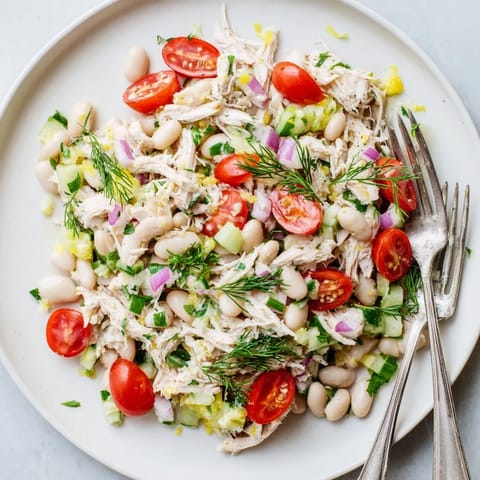 Fork-tender shredded chicken and creamy white beans mingle with crisp celery and fresh herbs in this vibrant Lemony White Bean Chicken Salad, glistening with citrusy vinaigrette.