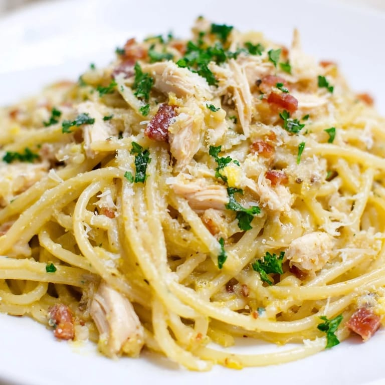 A skillet of homemade Chicken Carbonara with glossy egg sauce, pancetta, and al dente spaghetti, ready to serve.