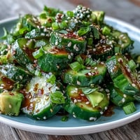 Vibrant smashed cucumber and avocado salad with toasted sesame seeds, a fresh side.
